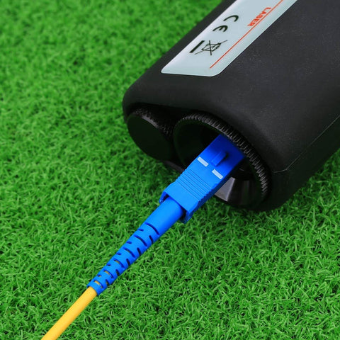 Fiber Optic Inspection Microscope With 400x LED Illumination Handheld Anti Slip Grip Easy Focus Includes SC LC FC Adapters For Fiber Cable Inspection And Detection Eye Safe Laser Filter connected to fiber cable on grass