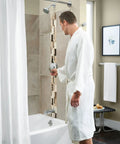 Man in robe adjusting Genta LX Pressure Balancing Shower Set with showerhead and tub spout, chrome finish lever handle in modern bathroom.