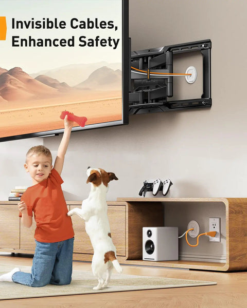 Child and dog near TV cord hider for wall mounted TV and speakers; in wall cable management kit installed.