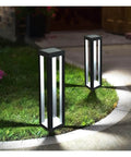 Outdoor Solar Floor Lanterns Set Of 2, Stainless Steel Black Lantern Lights illuminating a garden pathway at night