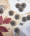 Knockout Vintage Screw Back Buttons 30mm Round Conchos Black Artificial Turquoise on a surface with decorative leaves.