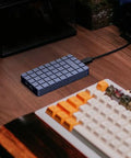 No Sweat M2 NVMe SSD Enclosure Rugged Aluminum USB4 External Drive Case on wooden desk next to keyboard.