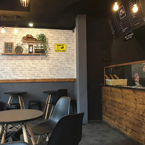Two Pack Smile Youre On Camera Sign For Outdoor Video Surveillance Signs UV Printed Aluminum 10 By 7 Inches in a café interior