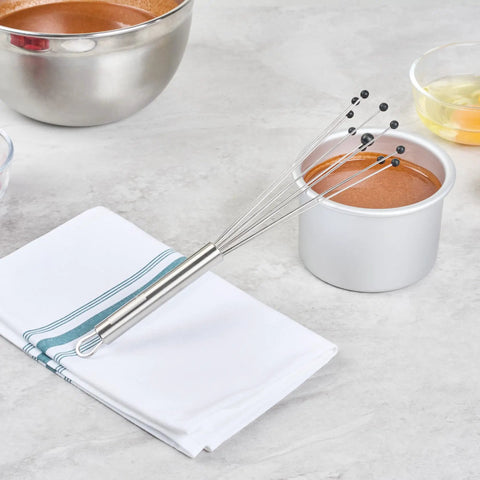Stainless Steel Ball Whisk With Silicone Tips 10.5 Inch 24 Pack Non Scratch Dishwasher Safe next to baking items on counter