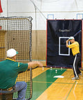 Man practicing batting with 6x8Ft Batting Cage Backstop With Heavy Duty Padding And Strike Zone Vinyl Net Protector
