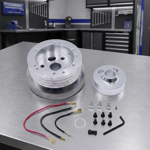 Boss Level Billet Steering Wheel Hub Adapter For 5 Or 6 Hole Whips In Sleek Silver Polish Aluminum Alloy with accessories on workbench.