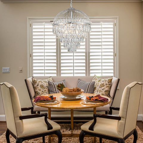 Dining room with Nine Light Crystal Chandelier With K9 Crystals, Chrome Finish, Modern Luxe Vibe, over round table and chairs.