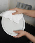Person cleaning a plate with Linen Terry Bar Mop Towels 14x17 White Value Pack Of 60 Absorbent And Durable Multipurpose Cleaning Rags