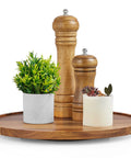 12-inch acacia wood lazy Susan turntable on round tray with two wooden spice grinders and small potted plants