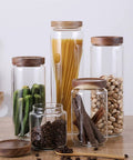 Straight Up Solid Airtight Coffee And Tea Storage Canister With Smooth Wood Lid Absolute Badass Upgrade For Your Countertop This Food Grade Sealed Jar displaying various food items in glass jars.