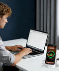 Man working on laptop with Three In One Magnetic Wireless Charging Station For Apple And Samsung Dope Qi2 Certified 15W nearby.