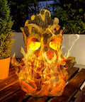 Epic Outdoor Solar Lantern With Realistic Flickering Flame From Resin Tree Stump Decor on a wooden table at night