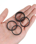 Hand holding 12Pcs Aluminum Headset Spacers For 1 1 8 Inch Stems 4 Thicknesses 2mm 3mm 5mm 10mm Black Stem Spacers