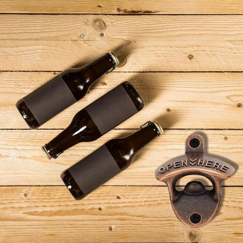Badass 2 Pack Wall Mounted Beer Bottle Opener, Rustic Heavy Duty Metal For Bars And Game Rooms, Comes With All Screws For Straight Up Easy Setup, Smooth Twists Make Opening Bottles A Cinch with dark beer bottles on wooden surface.