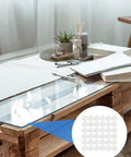 Heavy Duty Adhesive Non Slip Bumper Dots For Glass Tables And Cabinets Provide Dang Good Grip While Keeping Furniture Straight Up Safe From Daily Scratches And Slipping Hazards on a glass table with decor.