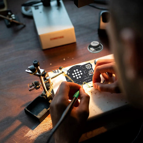Hands assembling AM FM Radio Kit For Learning And Practice A Hands On Soldering Project That Teaches Electronics on a workbench.