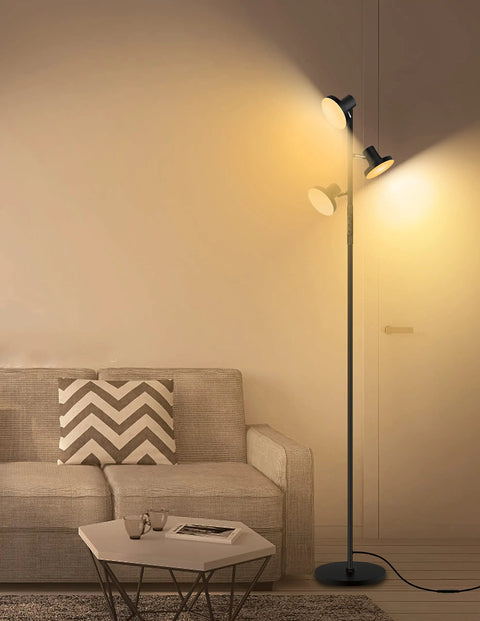 LED Tree Floor Lamp With 3 Adjustable Rotating Heads And Stepless Dimming, placed beside a sofa in a modern room.