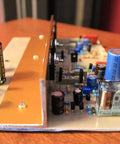 Side view of circuit board featuring capacitors and resistors mounted on Five Pack 10x10 Cm Copper Clad PCB Boards Single Sided Blank Fiberglass Prototyping Boards 1.5mm Thick With Clean Copper Layer And Solderable Pads For DIY Electronics Projects.