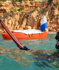 Spearfishing Float Boat With Carry Straps Foldable Flagpole And Compact Storage Red Buoy in water near diver