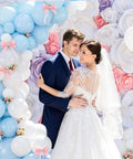 Elegant wedding with Arch Clip Kit For Balloons, white and blue balloon garland, floral backdrop, bride and groom embracing.