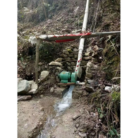 1000W Hydroelectric Water Turbine Generator 220V Off Grid Power System installed in a stream with visible copper coil housing