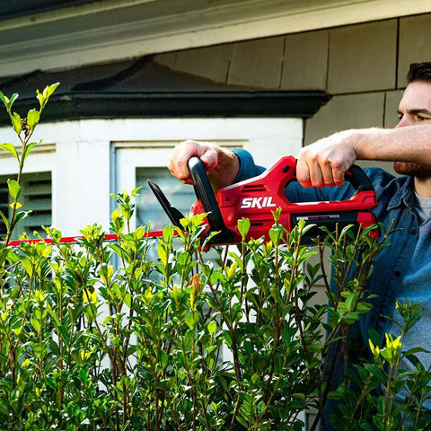 Man uses PWR Core 40 Brushless 40V Cordless Hedge Trimmer Kit With 24 Inch Dual Action Blade Three Quarter Inch Cut Capacity Includes 2.5Ah Battery And Auto PWR Jump Charger No Gas Quiet Long Lasting Power For Home Hedges to trim bushes.