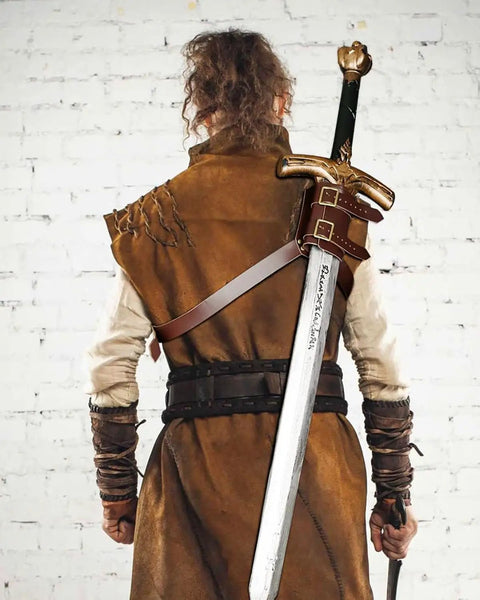 Back view of medieval costume with Back Sword Holster Leather Sword Holder With Adjustable Buckle on white brick background.
