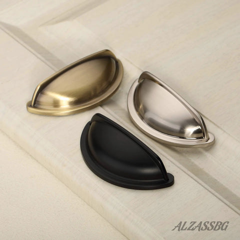 Brushed satin nickel, black, and brass cabinet cup pulls on a white surface, 3 inch hole centers 76mm for cabinets and drawers.