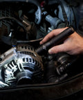 Person using Strion LED HL 615 Lumen Rechargeable Professional Flashlight to illuminate car engine in dim lighting conditions.
