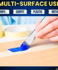 Hand using brush with blue paint alongside Beige Painter Tape For Crisp Lines And Trim, 0.7 Inch By 60 Yards on wood surface