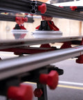 Close-up of Heavy Duty Adjustable Tile Table For Large Format Ceramic Sheets Extending 43 To 59 Inches with red clamps and supports.