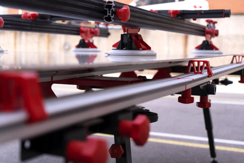 Close-up of Heavy Duty Adjustable Tile Table For Large Format Ceramic Sheets Extending 43 To 59 Inches with red clamps and supports.