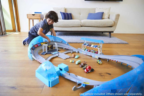 Child playing with Ultimate Florida Speedway Track Set with Lightning McQueen car and motorized booster on a 5-foot track