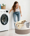 Woman using 65L Large Woven Cotton Rope Laundry Basket With Reinforced Handles No Snag Edges Rugged Hamper in laundry room
