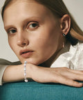 Model wearing a bracelet with antique silver daisy flower spacer beads, showing jewelry application for DIY crafts, close-up