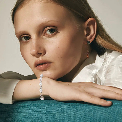 Model wearing a bracelet with antique silver daisy flower spacer beads, showing jewelry application for DIY crafts, close-up