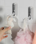 No Sweat Foldable Invisible Wall Hooks Zinc Alloy Storage Hangers 4 Pack for hanging a shower brush and pouf in bathroom.