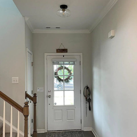 Matte Black Flush Mount Ceiling Light With Clear Glass Shade for hallways in modern vintage style, above entryway door.