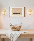 Wireless Boho Rattan Wall Sconce Set of Two illuminating a cozy room with brass accents and a decorative wall art.