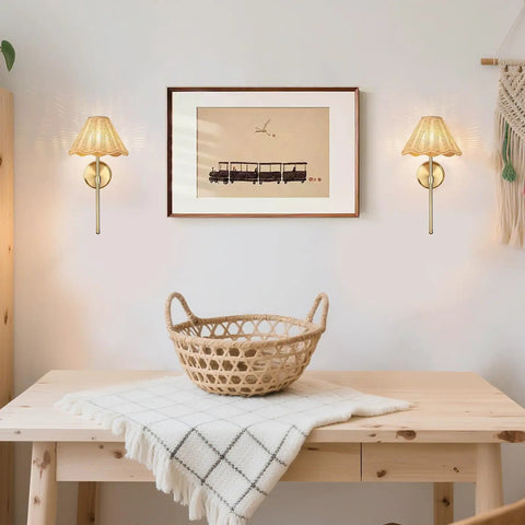 Wireless Boho Rattan Wall Sconce Set of Two illuminating a cozy room with brass accents and a decorative wall art.