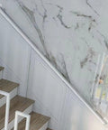 Rock Solid Eight Point Two Foot Modern Wrought Iron Grab Rail With Heavy Duty Wall Mount Brackets Smooth White Finish installed on interior staircase.