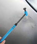 Pro Grade Multi Head Paintless Dent Removal Hammer Kit in hand, blue alloy head tapping out scratches on car panel.