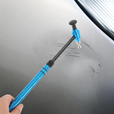 Pro Grade Multi Head Paintless Dent Removal Hammer Kit in hand, blue alloy head tapping out scratches on car panel.