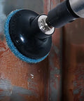 Close-up of a right-angle pneumatic die grinder with a blue 2-inch roll-lock sanding disc attached.