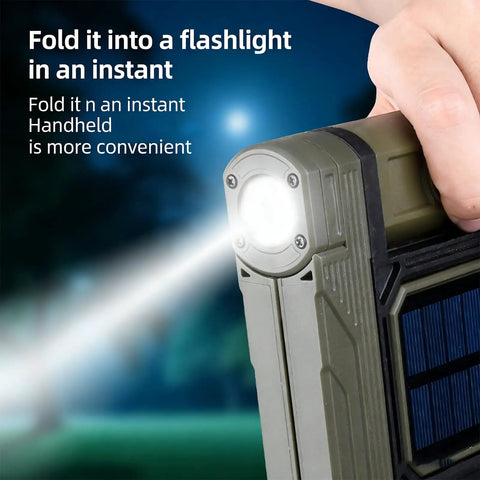 Hand holding Portable Telescopic Camping Light with Adjustable Stand and Built In Power Supply in flashlight mode at night