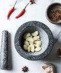Granite Mortar And Pestle Set For Grinding Spices And Herbs Like A Boss with garlic cloves in bowl on marble surface
