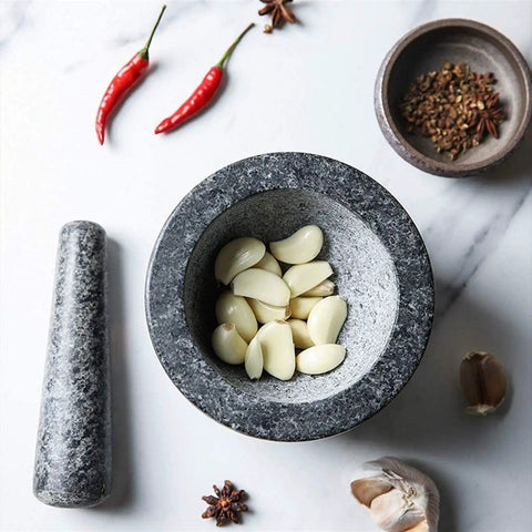 Granite Mortar And Pestle Set For Grinding Spices And Herbs Like A Boss with garlic cloves in bowl on marble surface
