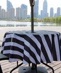Outdoor Round Tablecloth 60 Inch With Zipper Umbrella Hole Water Resistant Polyester Durable Patio Garden Table Cover For BBQs And Parties Easy To Clean Shrink Resistant Black on patio table with cityscape background