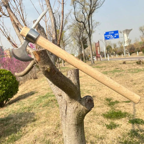 Stainless Steel Double Headed Pickaxe With Wood Handle And Comfort Grip displayed on a tree in a garden setting