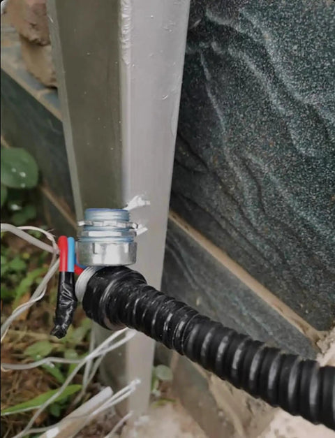 Close-up of Heavy Duty Flexible Metal Conduit Tough As Nails Black Pvc Covered connecting to a metal structure.